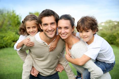 Parents giving piggyback ride to children, © goodluz - Fotolia.com